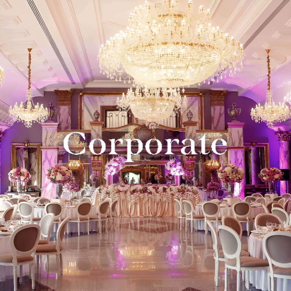 Elegant Neelam Indian Cuisine dining hall with chandeliers, purple lighting, and tables set for an event.